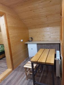 a wooden sauna with a wooden table and a bench at На горі in Vorokhta