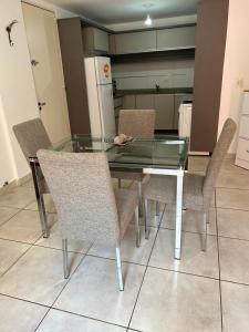 uma mesa de vidro e cadeiras numa cozinha em Departamento Lima B General Paz con Pileta em Córdova