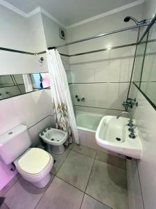 a white bathroom with a toilet and a sink at Departamento Lima B General Paz con Pileta in Córdoba