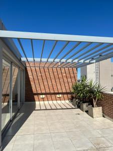 a pergola on a building with a patio at Departamento Lima B General Paz con Pileta in Córdoba