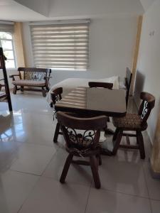 uma sala de estar com uma mesa e duas cadeiras em El Oasis Fomeque em Fómeque