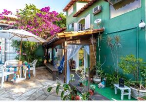 Búzios Casa Verde في بوزيوس: فناء منزل بطاولة ومظلة