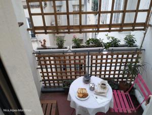 einen Tisch und Stühle auf einem Balkon mit Pflanzen in der Unterkunft Charmant et calme face gare centrale in Nizza