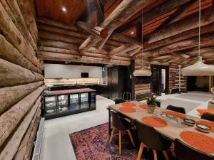 kuchnia i jadalnia z drewnianą ścianą w obiekcie Villa Uuttu w mieście Kuusamo