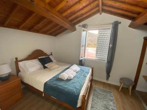 a bedroom with a bed and a window at Casa da Ribeira - Mosteiros in Mosteiros