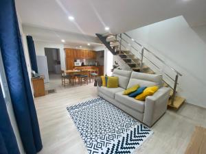 a living room with a couch and a staircase at Casa da Ribeira - Mosteiros in Mosteiros
