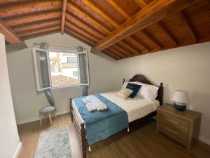 a bedroom with a bed with two towels on it at Casa da Ribeira - Mosteiros in Mosteiros