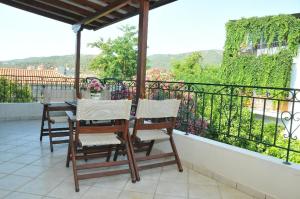 un porche con 2 sillas y una mesa en el balcón en Zouzoula House, en Milina