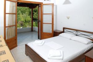 um quarto com uma cama e uma varanda em Zouzoula House em Milína