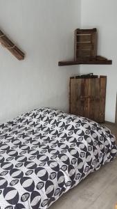 a bed with a black and white comforter in a room at Studio agréable in Les Contamines-Montjoie