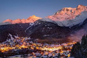 a town in the mountains with a snow covered mountain at Studio agréable in Les Contamines-Montjoie