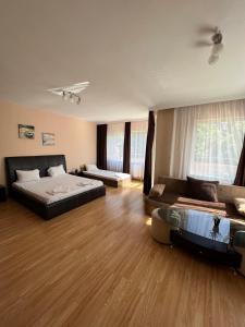Habitación grande con 2 camas y sofá en Escape Shumen, en Shumen