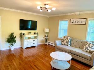 a living room with a couch and a tv at Forest and River Side Tranquil House in Montague