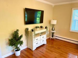 sala de estar con tocador blanco y TV en la pared en Forest and River Side Tranquil House, 
