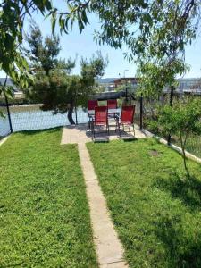 a patio with red chairs in a yard at Apartma soline Seča in Portorož