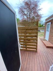 a wooden fence with a gate on a deck at South London Private Guest Studio in Sydenham