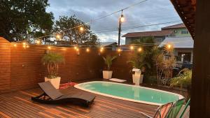 un patio con piscina y terraza de madera en Casa aconchegante, en Florianópolis