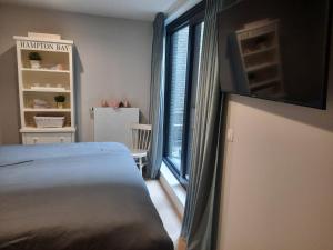 um quarto com uma cama e uma grande janela em lectus IV em Nieuwpoort