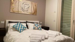 a white bed with pillows on top of it at Appartamento “Le vele” in Porto San Giorgio