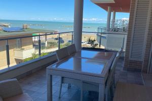 波爾托聖焦爾焦的住宿－Appartamento “Le vele”，阳台配有桌子,享有海滩美景