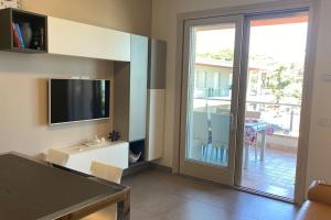 un soggiorno con porta scorrevole in vetro e TV di Appartamento “Le vele” a Porto San Giorgio