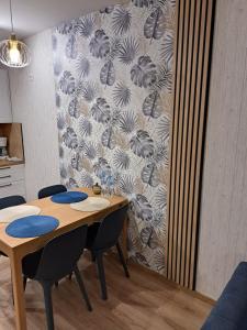 una mesa y sillas en una cocina con pared en Apartament Waldi en Kołobrzeg