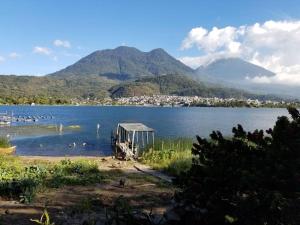 a lake with a small building in the water at Chalet in the Woods in Santiago Atitlán