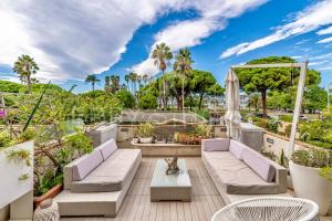 un patio con sofás, mesas y árboles en Appartement l'Age d'Or, en Cannes