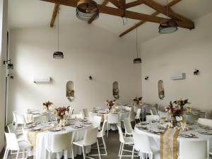 uma sala com mesas brancas e cadeiras com flores em DOMAINE LA MASQUIERETTE em Villepinte