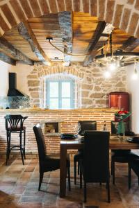 a dining room with a table and chairs and a stone wall at Villa Kotli Stone House in Kotli