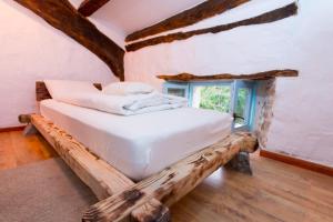 a bedroom with a bed made out of logs at Villa Kotli Stone House in Kotli