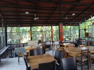 a restaurant with tables and chairs and windows at Amazon Lodge Varillal in Iquitos