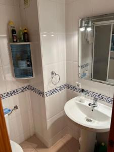 Baño blanco con lavabo y espejo en Apartamento en Costa Ballena, Urb. Playa Ballena, en Cádiz