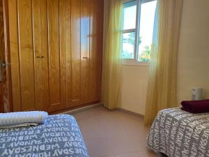 1 dormitorio con 1 cama y armario de madera en Apartamento en Costa Ballena, Urb. Playa Ballena, en Cádiz