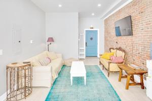 ein Wohnzimmer mit Sofa und Ziegelwand in der Unterkunft Spacious Oasis - Parking, Private Patio & Roofdeck in Philadelphia