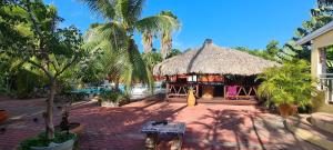 un edificio con una cabaña de paja con palmeras en Woodstock Palmresort Curaçao, en Willemstad