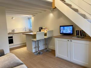 een keuken met een bureau en een tv op een aanrecht bij The Little Stable at Flos Cottages in West Coker