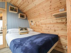 een bed in een kamer met een houten muur bij Whernside in Clitheroe