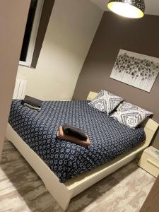 a bedroom with a bed with a blue comforter at #GREENHOME# in Dunkerque