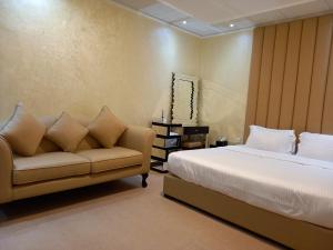 a bedroom with a bed and a couch at Holiday Homes in Ras al Khaimah