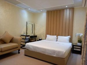 a bedroom with a white bed and a chair at Holiday Homes in Ras al Khaimah