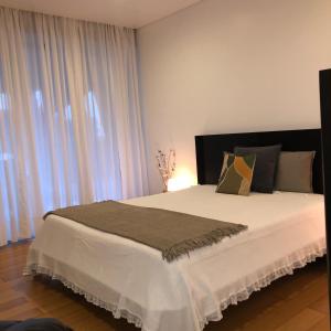 Schlafzimmer mit einem großen weißen Bett mit Vorhängen in der Unterkunft Crystal House in Angra do Heroísmo