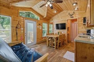 a log cabin kitchen and living room with a table and a couch at Adorable little cabin #28 in Kernville