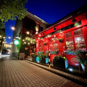 キェルツェにあるShoemaker Irish Pub & Accommodationの夜の花のレストランを提供しています。
