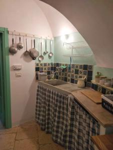 a kitchen with a sink and a counter with pots and pans at Il Trullo del Nonno a Cisternino in Cisternino
