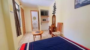 a bedroom with a bed and a table and a chair at Posada El Campanario in Valle de Bravo