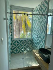 y baño con ducha acristalada y lavamanos. en Hotel Caribbean Cartagena en Cartagena de Indias