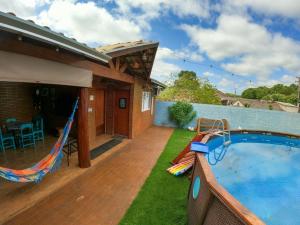 a backyard with a swimming pool and a hammock at Casa Victour, localização privilegiada in Bonito