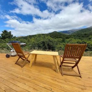 a picnic table and two chairs sitting on a deck at Studholme Glamping in Hunter