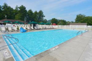 a large swimming pool with chairs and umbrellas at Lake George Escape in Lake George